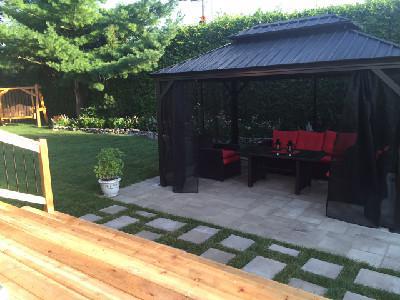 Côté jardin, à partir des marches de la maison : vue sur la nouvelle pergola posée sur le patio.