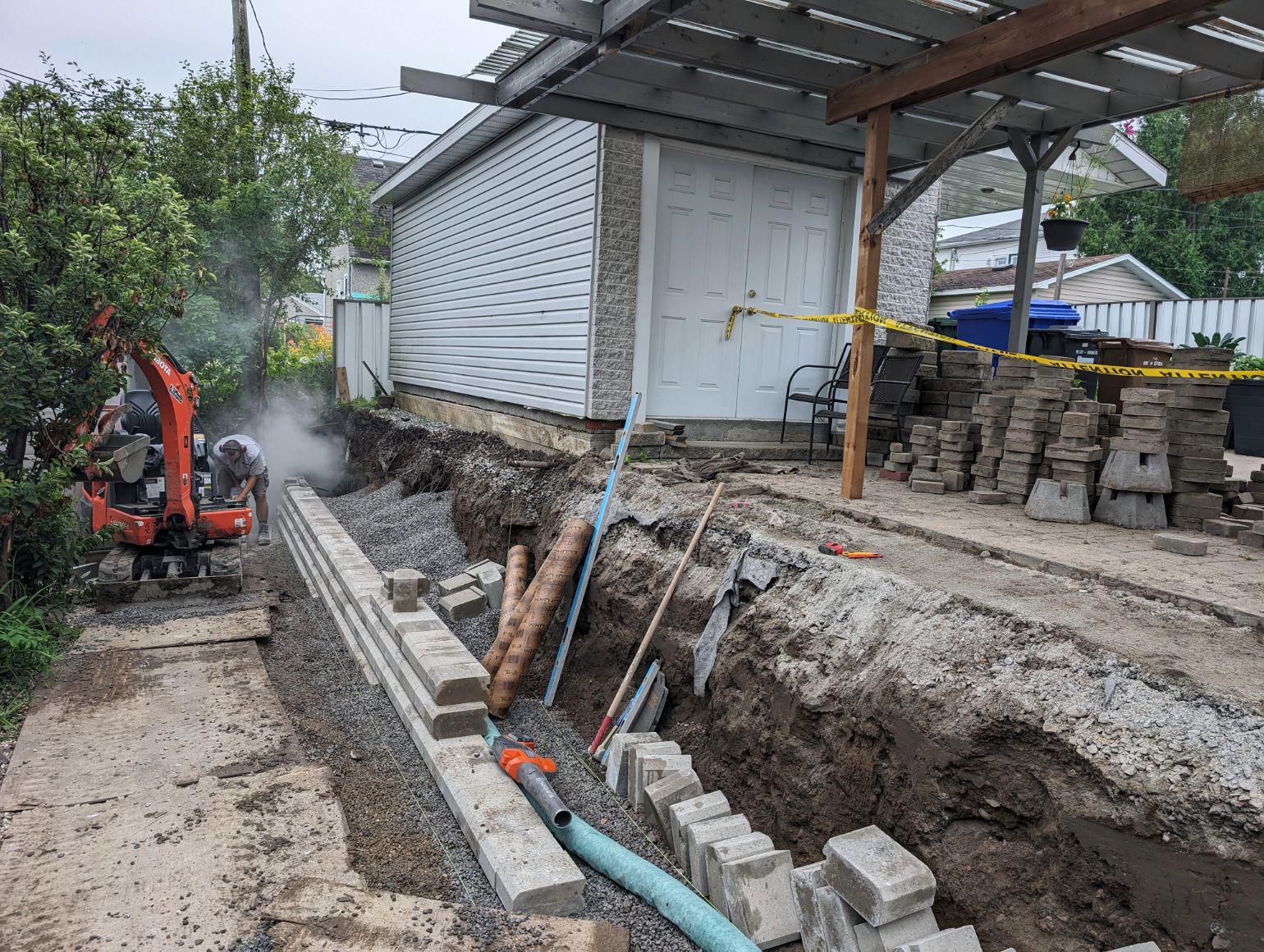 Image 3 : les briques du nouveau mur sont posés sur une couche de roche concassée