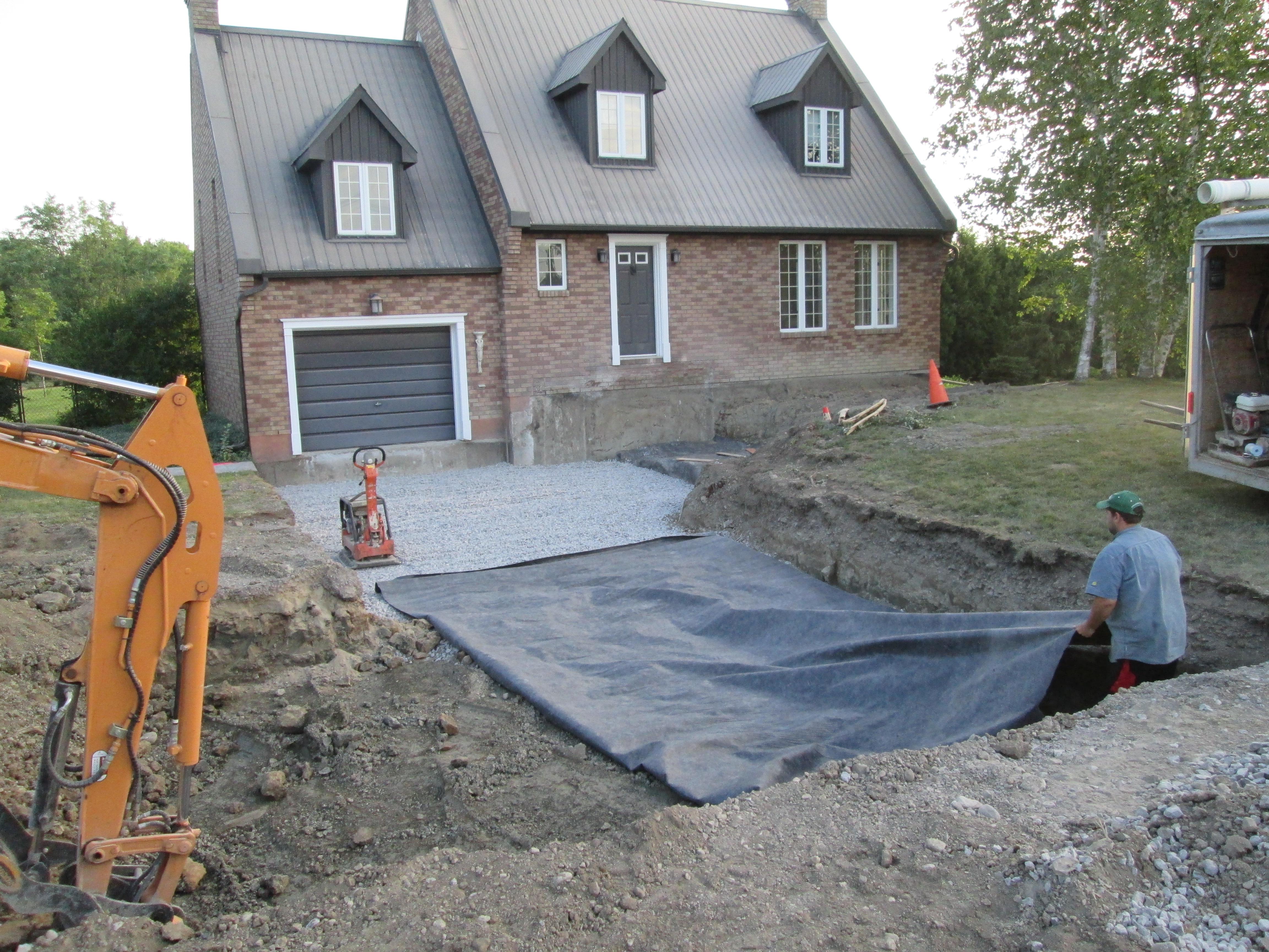 Image 3 : une toile géotextile est posée sur la nouvelle couche de pierres concassées dans l'entrée